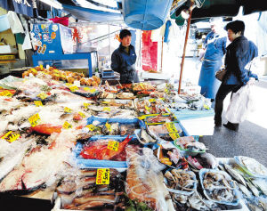 5日，卖家在东京一家海鲜摊上招揽顾客